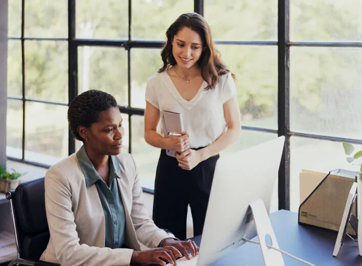 An advisor and a client reviewing the books together at a computer